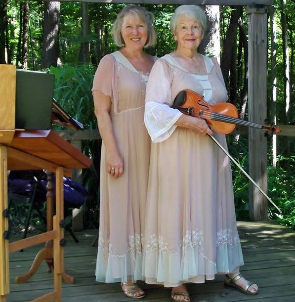 women standing together holding violin