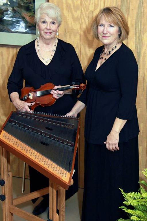 women standing and holding musicial instruments
